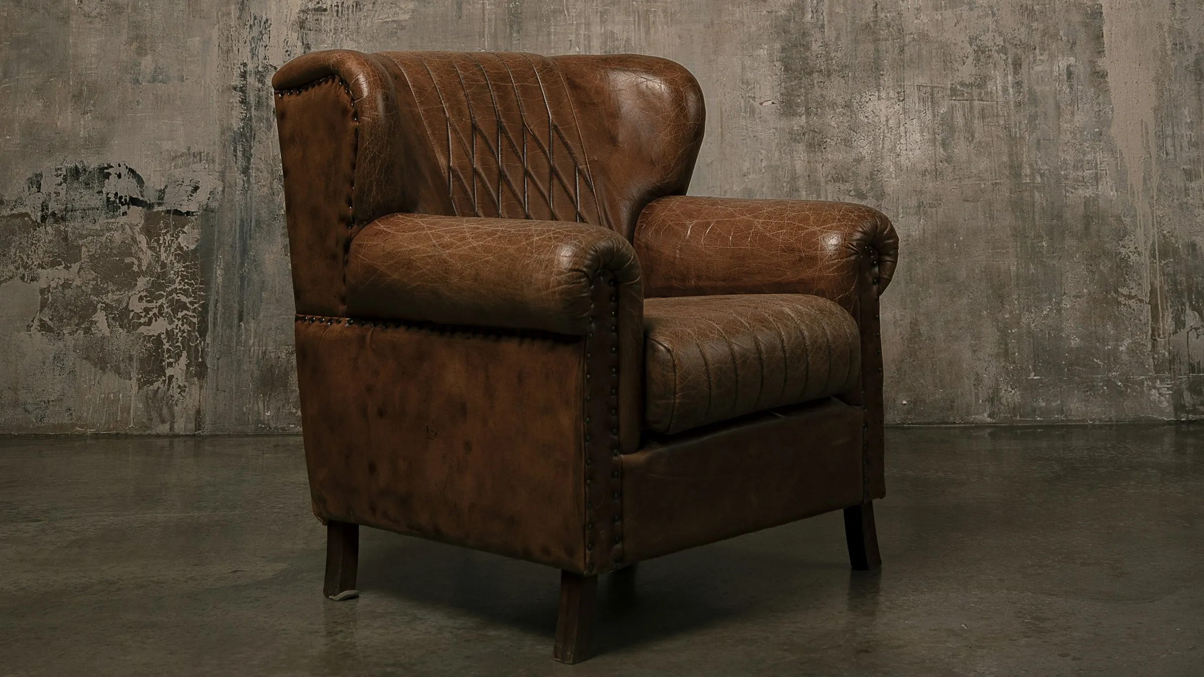A wooden-framed armchair against a plain white wall