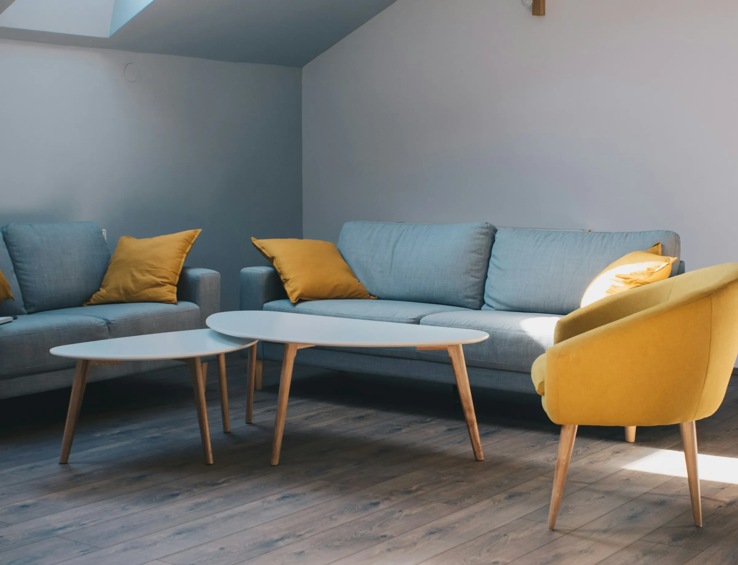 A white coffee table in front of a gray fabric sofa