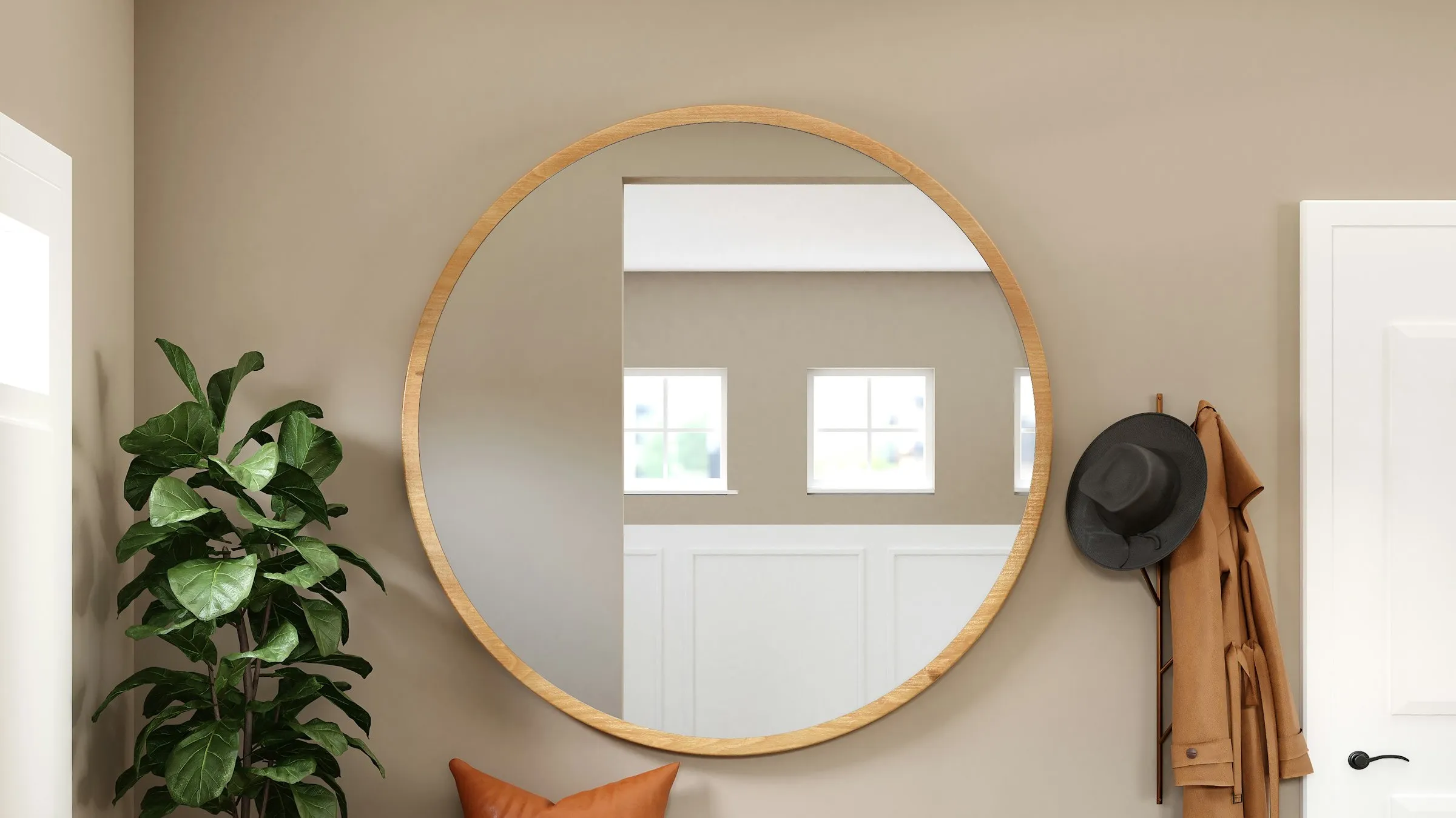 A wood-framed mirror on a white entryway wall